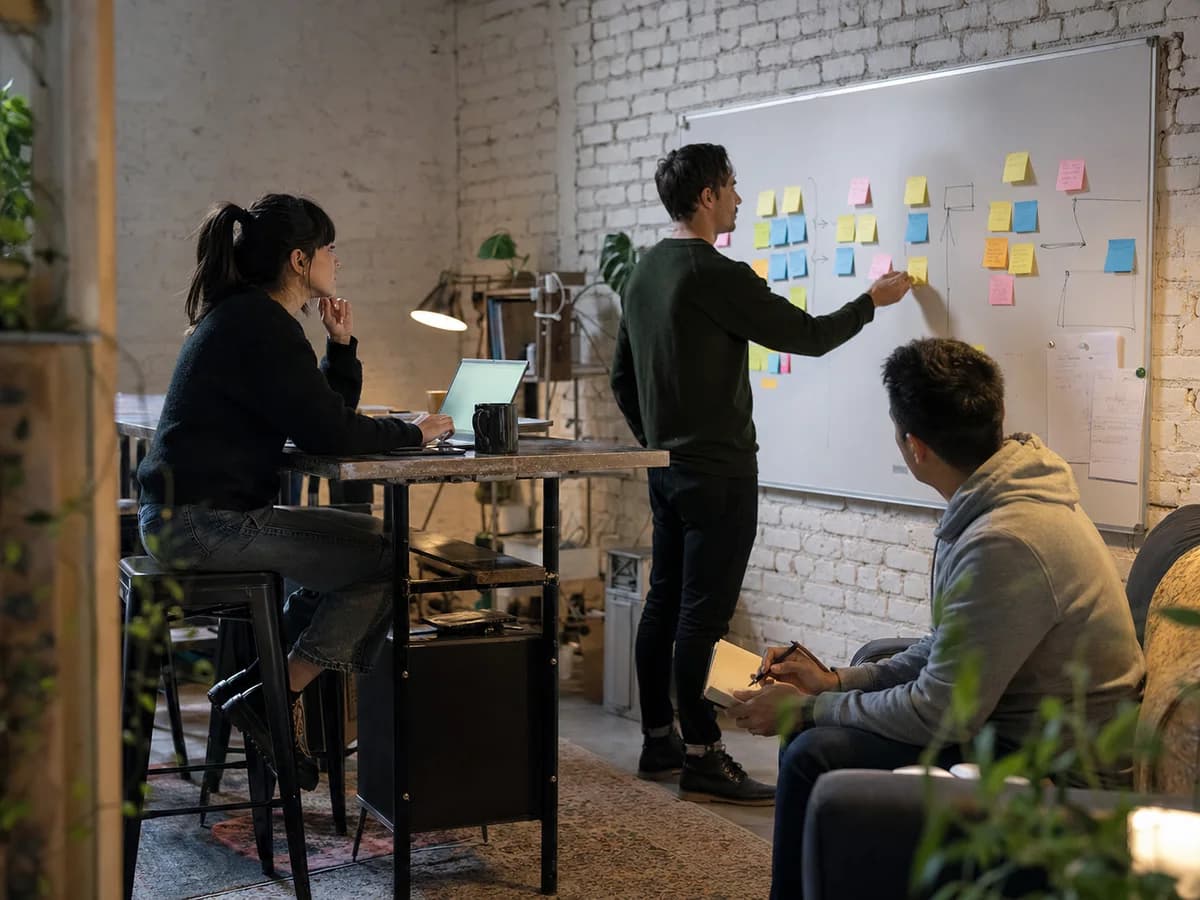 Startup founders organizing customer workflow notes in a compact studio